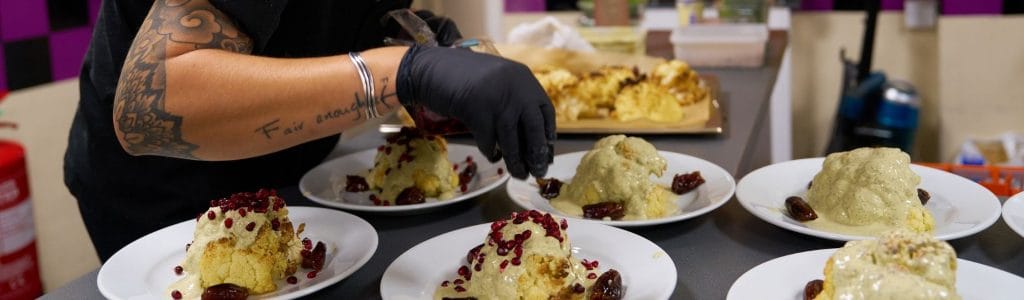 Chef from Happy Plate carefully plating food for event catering service