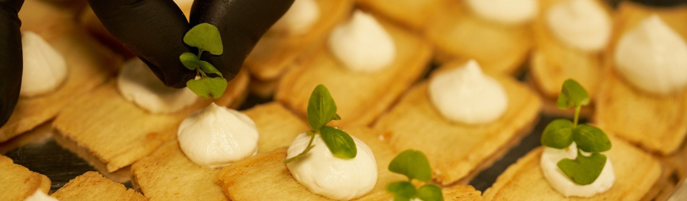 Chef plates a canapé ready for service at an event